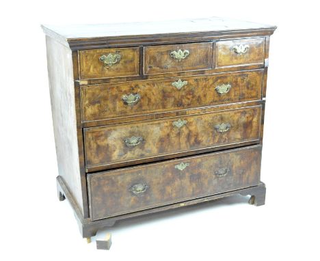 A veneered Georgian chest of drawers with with brass handles and three short over three long drawers, raised on bracket suppo