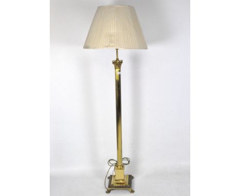 A reproduction standard lamp, the brass frame modelled as a ribbed column positioned on a plinth and supported by four claw f