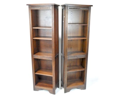 A pair of contemporary bookcases by Wood Bros's Furniture Ltd, the stained oak structures of slender form with adjustable she
