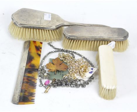 A selection of silver backed ladies' accessories, comprising two brushes and a comb, together with an ivory backed brush and 