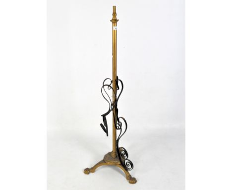 A gilt metal painted standard lamp, raised upon tripod lion paw feet, 121cm high