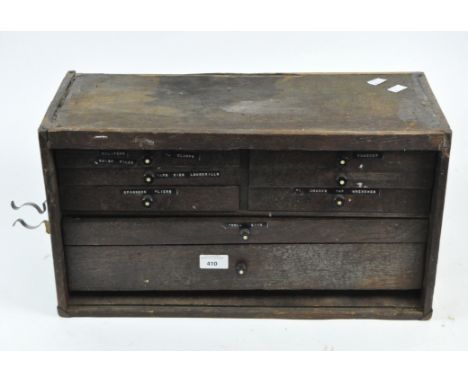A vintage wooden tool box, with multiple small drawers and compartments containing a variety of tools and implements, with 51