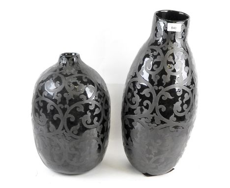 Two ceramic vases, glazed in black and decorated in swirling motifs, height of tallest 51cm