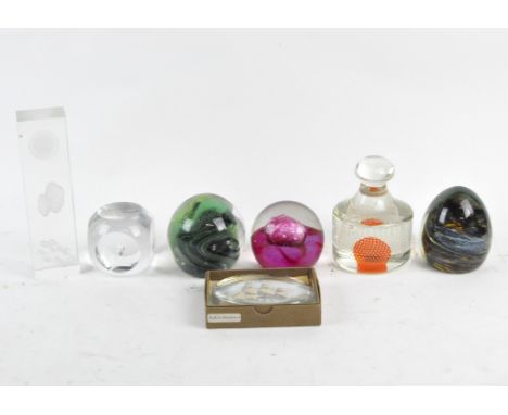 A collection of glass paperweights, including a pink Caithness example, a Mdina green example, one depicting the H.M.S. Penel