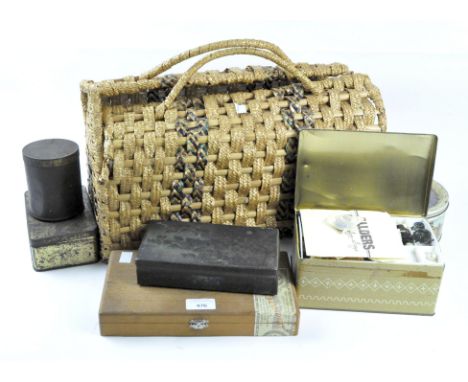 A collection of sewing related tools and implements, including buttons and cotton reels, all in a wicker basket