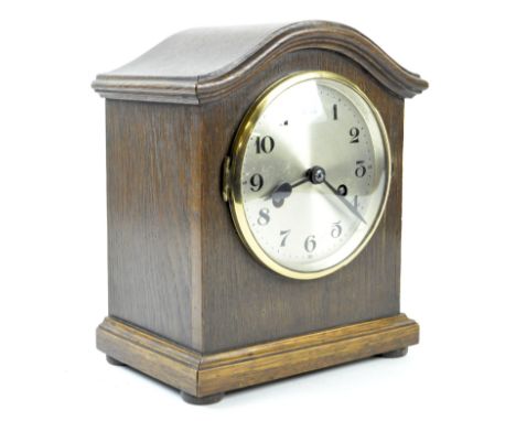 A 1930's German mantle clock, the oak cased raised upon flat bun feet, the dial with Arabic numerals denoting hours, 26cm hig