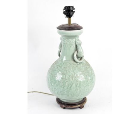 A Chinese celadon glazed baluster vase adapted as a lamp, with beast and ring handles, moulded with scrolling foliage, adapte