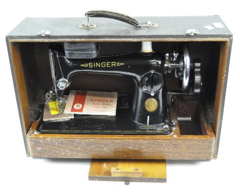 A late 19th century Singer sewing machine, with manual wind and black and gilt decoration, contained within a carry case