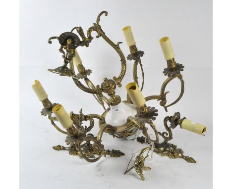 A six branch cast chandelier and pair of sconces, all cast in gilt metal with scrolling motifs, each containing artificial ca