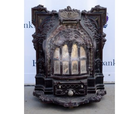 A Petit Modere Grand ornate cast iron and ceramic fireplace with hinged door revealing grate with ash drawer below. 80cm high