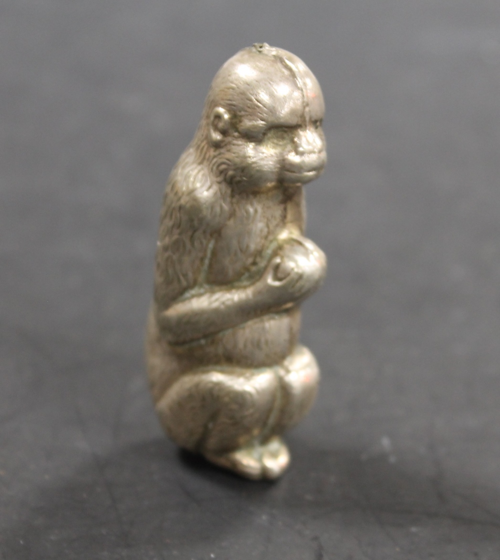a white metal monkey rattle a white metal monkey rattle