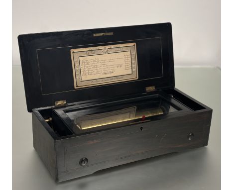 A Swiss (Geneva) comb and cylinder musical box, late 19th century, the part-ebonised case with rosewood cover centred by an i