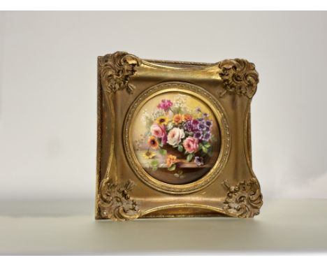 A Royal Worcester porcelain plaque painted by Ernest Phillips, circular, depicting a floral still life, signed lower right, p