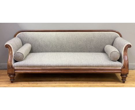 A Victorian mahogany sofa, the moulded and scroll carved show frame enclosing seat, back, and bolster cushions well upholster