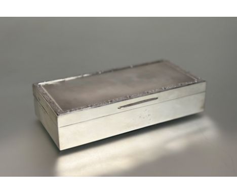 A George V silver cigarette box, Roberts &amp; Dore, Birmingham 1934, the engine-turned cover chased with a band of Celtic de