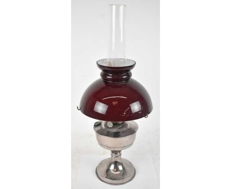 A 20th century silver plated oil lamp, with cranberry glass shade, height to top of chimney approx. 59cm.