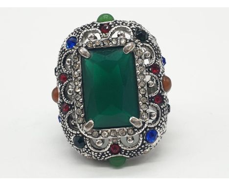 A multi coloured silver ring with jade centre stone. 22.7g in weight. Size L. 