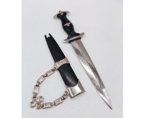 An interesting reproduction Nazi dagger with chain attached to its scabbard. German inscription on blade. 37cm long. 