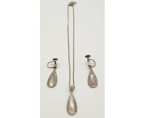 Silver jewellery set to include pendant on chain and matching pair of earrings. Mother of pearl design with filigree work sur