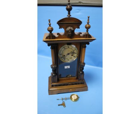 AN ANTIQUE WALNUT CASED MANTEL CLOCK