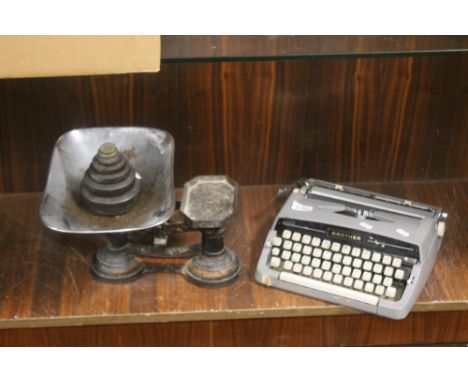A SET OF CAST IRON WEIGHING SCALES WITH PAN AND WEIGHTS AND A BROTHER PORTABLE TYPEWRITER