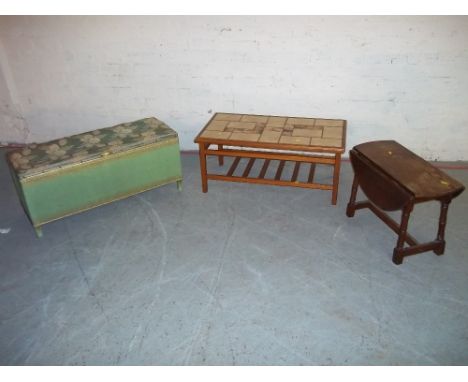 A RETRO TEAK TILE TOPPED COFFEE TABLE WITH STRETCHER SHELF, AN OAK TWIST TOP DROP LEAF SIDE TABLE, A LLOYD LOOM STYLE BLANKET