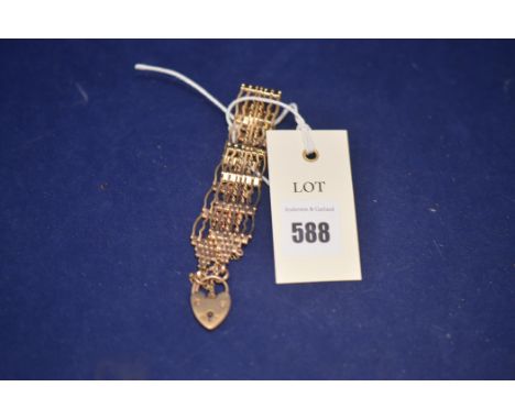 A 9ct. yellow gold gate link bracelet with heart-shaped clasp, 43.1grms.