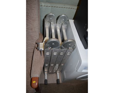 An aluminium ladder in four folding sections.