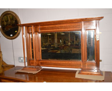 A mahogany satinwood bounded over mantel mirror with three bevel plates, 120cms wide.
