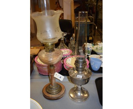 An oil lamp with wooden base; and another with metal reservoir and base.  (2)