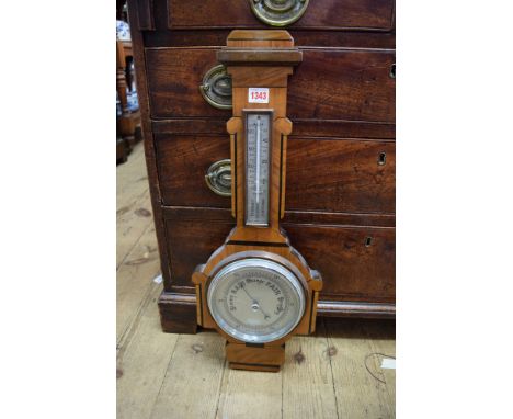 A 1930s walut and ebonized aneroid wheel barometer. 