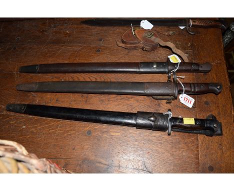 Three early 20th century bayonets and scabbards, one an Australian example stamped 'Mangrovite' on the scabbard.