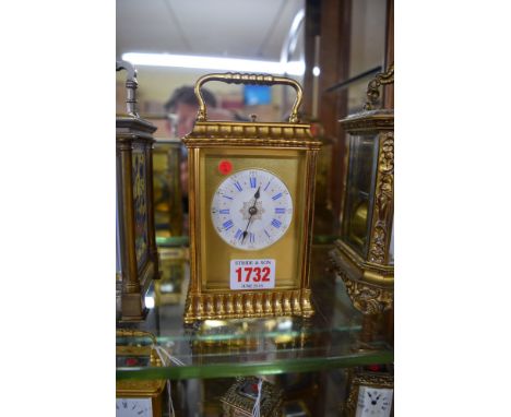 A brass carriage clock, in fancy gorge case and with circular enamel dial, repeating on a gong, height including handle 17.5c