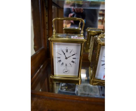 A large brass carriage clock, with alarm and push button repeat striking with two hammers on a gong, height including handle 