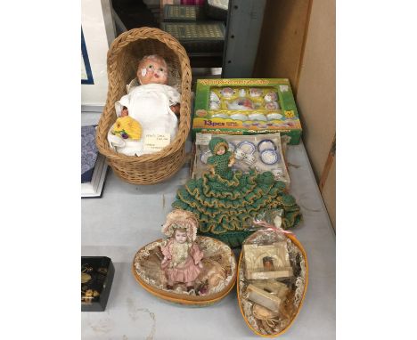 A VINTAGE 1930'S DOLL WITH WICKER CRADLE, TWO SMALLER DOLLS, A BOXED TEDDY BEARS TEA SET, A MINIATURE CERAMIC TEASET PLUS TWO