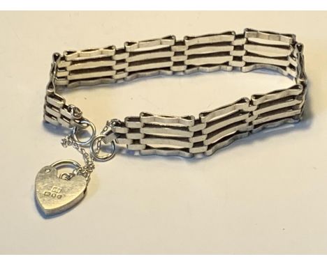 A SILVER FOUR BAR GATE BRACELET WITH A HALLMARKED LONDON SILVER HEART PADLOCK 