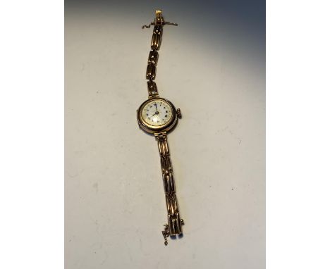 A 9 CARAT GOLD WATCH WITH A DECORATIVE WHITE ENAMEL FACE AND ROMAN NUMERALS GROSS WEIGHT 20.75 GRAMS 