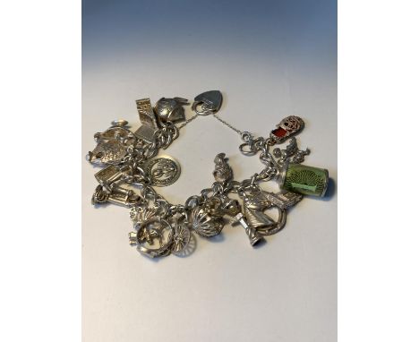 A SILVER CHARM BRACELET WITH TWENTY CHARMS AND A HALLMARKED LONDON SILVER HEART CLASP 