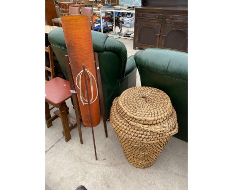A 1970'S RETRO ORANGE TUBE FLOOR LAMP WITH THREE SPLAY TEAK LEGS AND WICKER LINEN BASKET WITH LID 