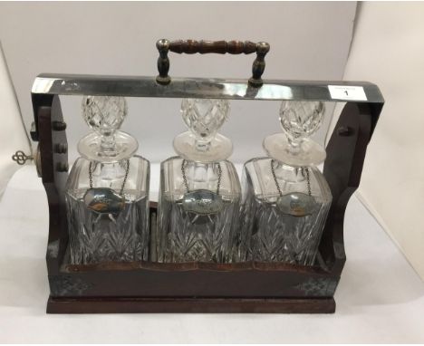 A VINTAGE THREE BOTTLE TANTULUS WITH THREE CUT GLASS DECANTERS, ALL WITH HALLMARKED SILVER DECANTER LABELS - PORT, WHISKY &am