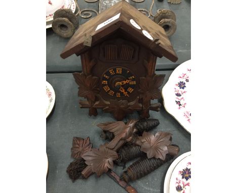 A WOODEN CUCKOO CLOCK COMPLETE WITH PENDULUM AND WEIGHTS 