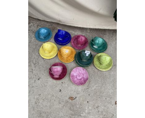 AN ASSORTMENT OF COLOURFUL CERAMIC CUPS, SAUCERS AND PLATES 