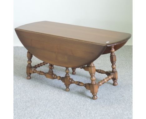 An Ercol dark elm drop leaf coffee table, 105cm