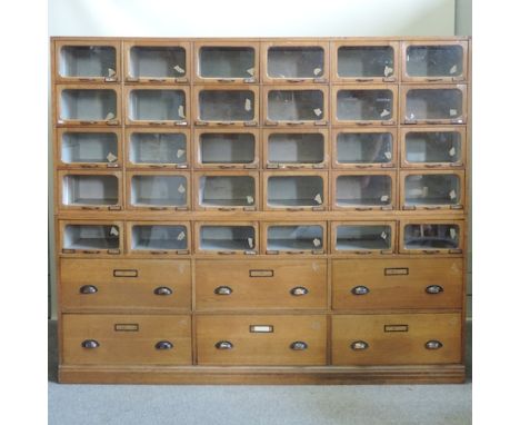 A large early 20th light oak haberdashery cabinet, fitted with glazed pigeon holes and drawers, 220cm