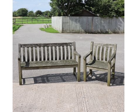 A teak garden bench, together with a matching armchair, and a folding garden chair, boxed