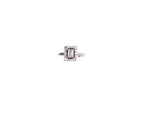 DIAMOND RING, 1920s the collet set step-cut diamond within a border of single-cut stones with square diamond corners size H, 