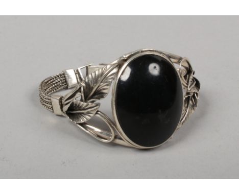 A silver bangle set with a large ovoid onyx tablet.