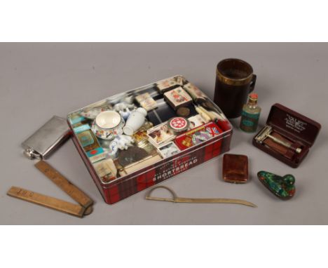 A tin of collectables to include Victorian wooden mug, cloisonne enamel duck, cigarette cards etc.