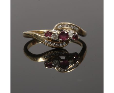 A 9ct gold ruby and diamond cross over ring, size R.