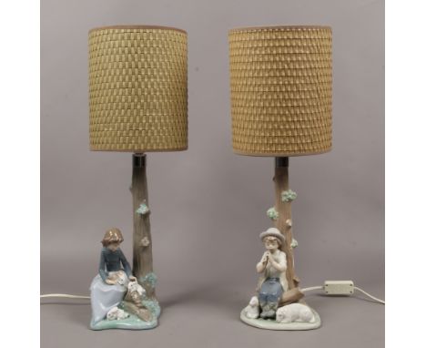 Two Nao table lamps, one surmounted with a boy and pair of lambs the other a girl with rabbits.